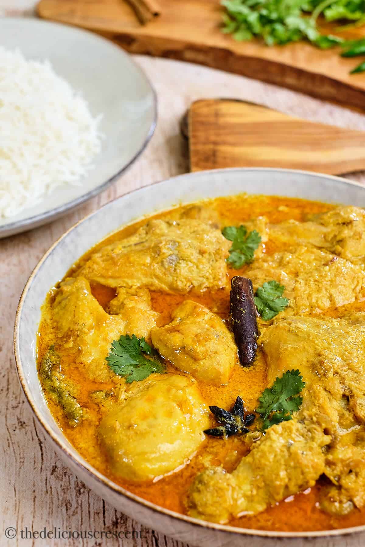 Chicken curry with coconut sauce served in a grey bowl.