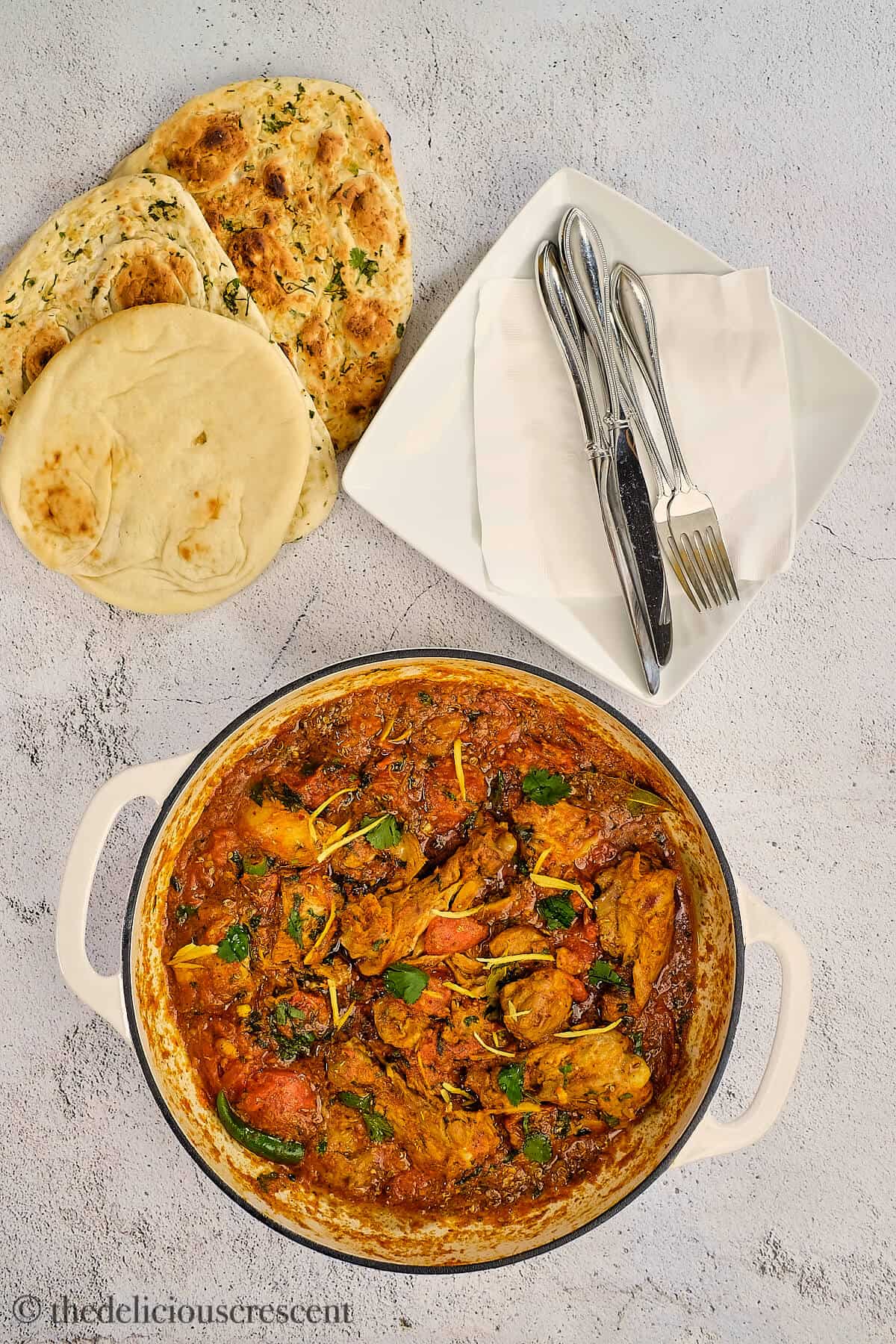 Overhead view of an Indian chicken stir fry with naan.
