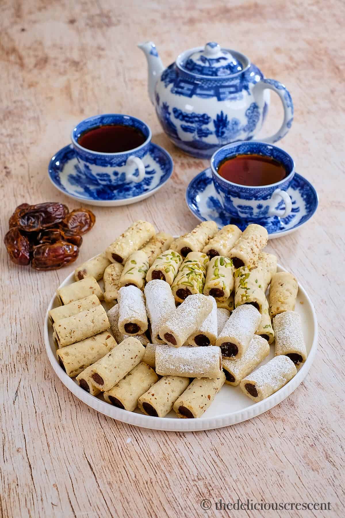 A plate full of date cookies served with tea.