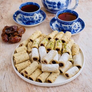 Close view of a plate full of date cookies served with tea.