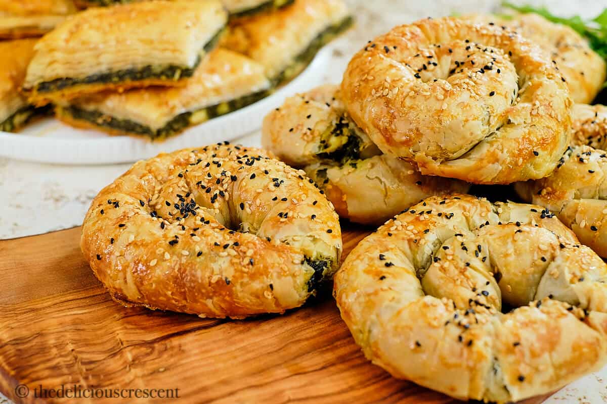 Spinach and feta cheese böreks on a wooden board.