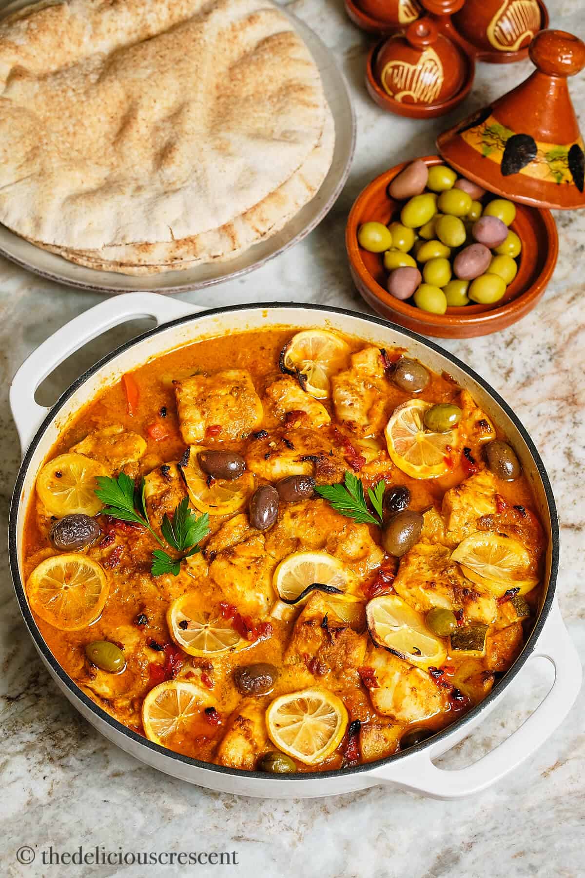 Moroccan fish stew served in a white cassserole dish.